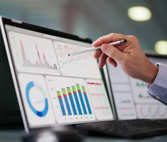 Person analyzing graphs on computer screen.