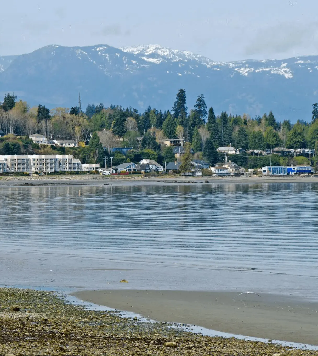Coastal town with mountains in the background.