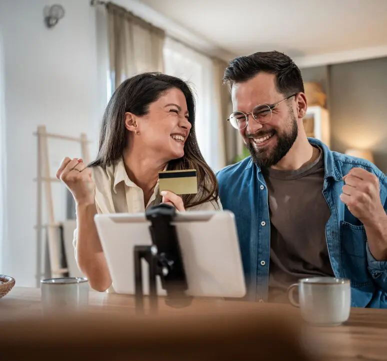 Couple celebrating online purchase at home.