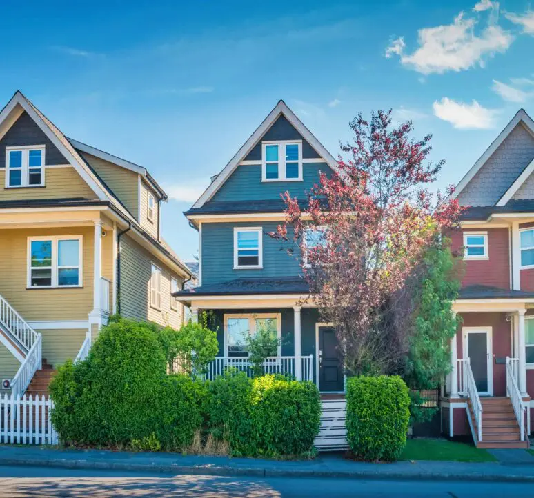 Colorful houses with trees and blue sky.