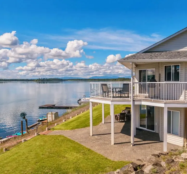 Lakeside house with patio and scenic view.