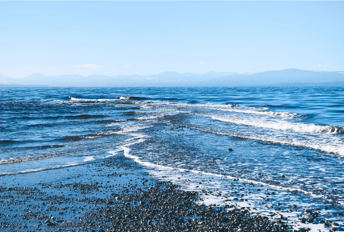 Ocean waves lapping on rocky shoreline.